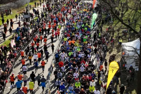 Tłum biegaczy na trasie maratonu, widziany z góry.